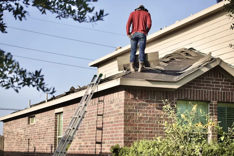 Professional roofer working on a residential roof in Foxborough